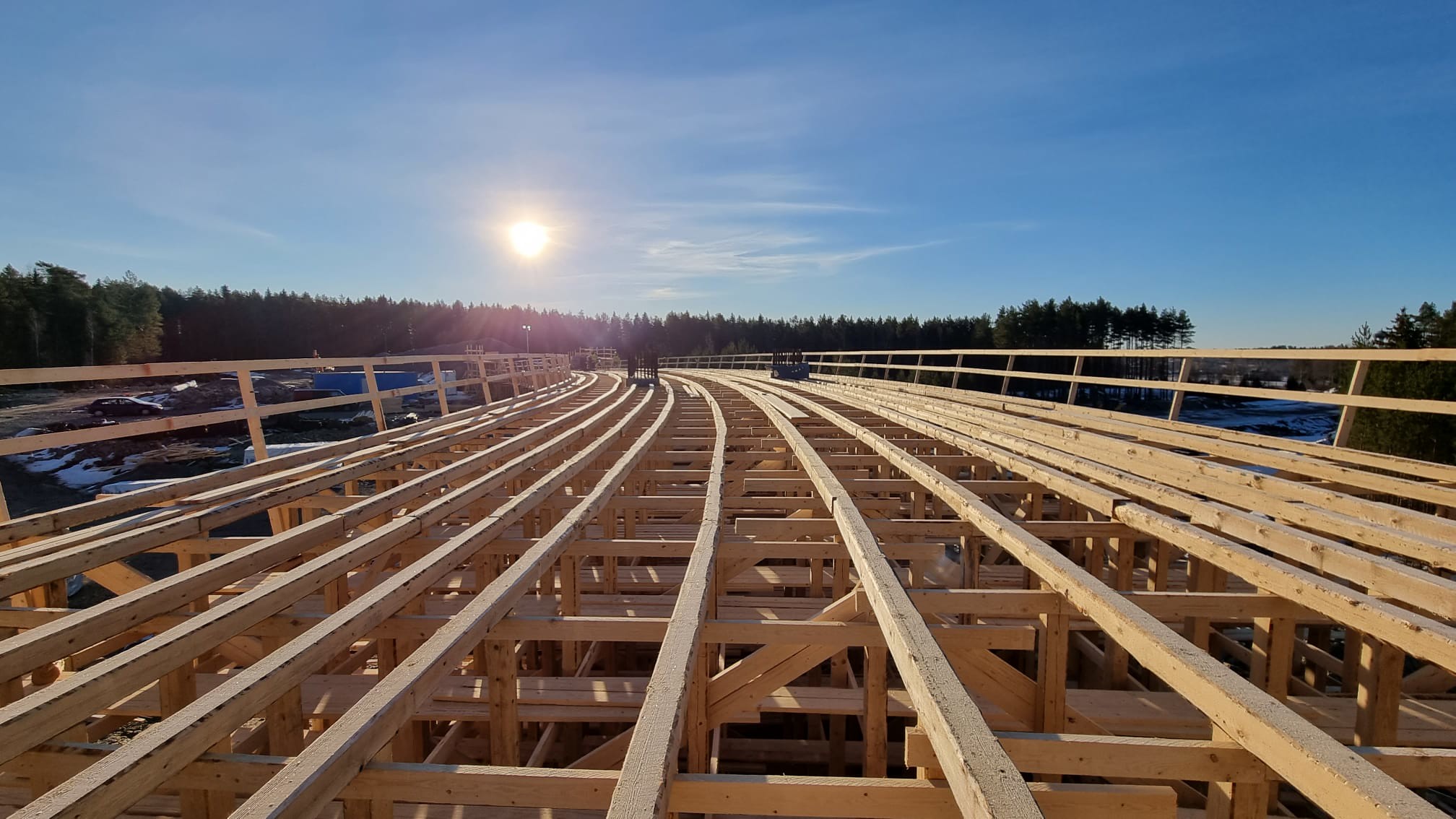 Aurinkoisena päivänä sillanrakennustyömaalla. Silta on rakennettu puuosista.